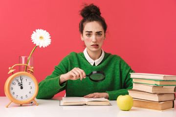 Pretty nerd girl sitting at the table isolated