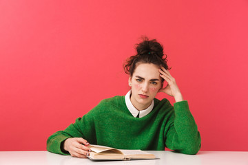 Pretty nerd girl sitting at the table isolated