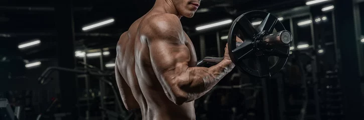 Foto op Plexiglas Aantrekkelijke lange gespierde bodybuilder die zware deadlifts doet in een modern fitnesscentrum. © romanolebedev