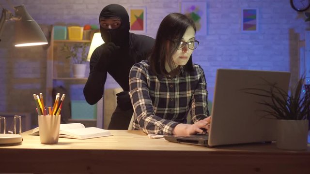Portrait of a burglar in a modern apartment at night
