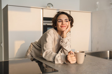 Smiling young woman having cup of tea