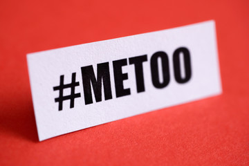 Hashtag 'metoo' printed on white paper on a red background.