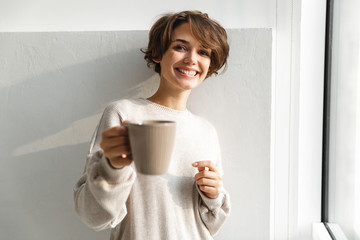 Smiling young woman having cup of tea
