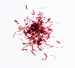 Saffron isolated on white. Saffron spice, the most expensive spice in the world. Red currant flowers on a white table. Spice with gold value.