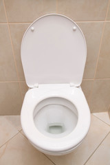White toilet. Closeup of the white toilet with open cover