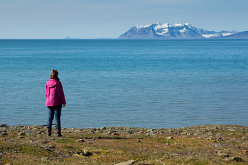 Fototapeta premium A girl stands on the shores of the Greenland Sea