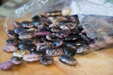 Close-up of colorful haricot beans, beans on wooden table