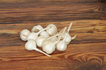 fruits of garlic lie on a wooden background