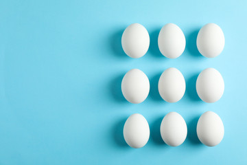 Flat lay composition with chicken eggs on color background, space for text