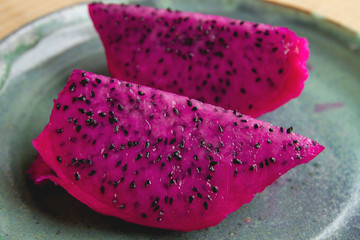 Pink dragon fruit or pitaya on a blue plate