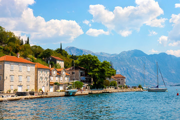 Fototapeta na wymiar Scenic panoramic view of the historical city of Perast, located in the Bay of Kotor on a sunny day with blue sky and white clouds in summer, Montenegro, southern Europe