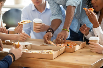 Diverse employees eating pizza during lunch break