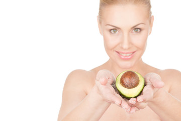 Beauty secrets. Attractive mature woman holding out half of an avocado in her hands and smiling joyfully