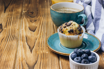 Freshly baked muffins with blueberry on the table.