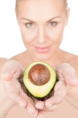 Natural skincare. Vertical closeup portrait of a beautiful woman holding half of an avocado in her hands