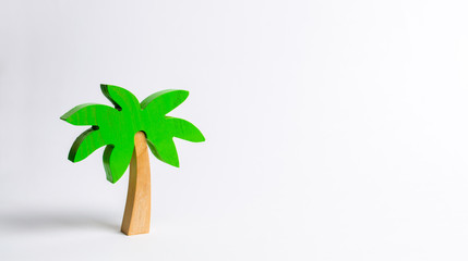 Fototapeta na wymiar Wooden palm tree on a white background. Conceptual leisure and vacation, entertainment and relaxation. Tours and cruises to warm countries. The development of tourism. Tropical island.