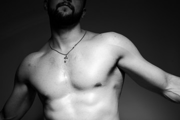 Fototapeta premium Black and white photo of a handsome and sporty guy close-up in studio