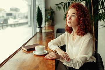 Young Attractive Woman Enjoying A Cup Of Coffee in Cafe