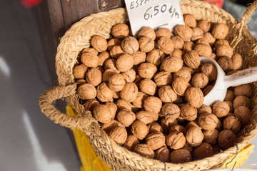 Closeup of collecting walnuts in a wicker handmade basket for sale.