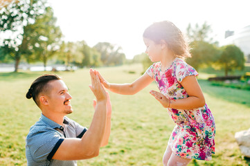 Dad and daughter summer outdoor activity. Loving father adore his lovely playful baby. Parent and...
