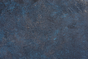 Textured dark rough background with blue and yellow spots