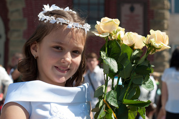 Portrait of cute little girl on white dress and wreath of first holy communion