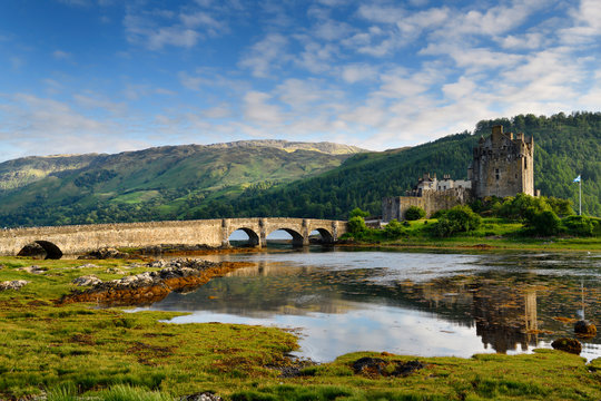 Evening light on restored Eilean Donan Castle with sun on added stone arch footbridge to the Island in Scottish Highlands Scotland UK