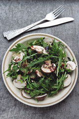 Salad with arugula and raw champignons. Healthy tasty vegan salad. Nutritious fitness salad. Keto lunch idea. Keto diet.