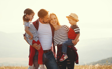 Happy family: mother, father, children son and daughter on sunset.
