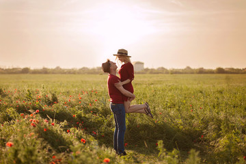 Fototapeta premium beautiful loving couple husband and wife in poppy field