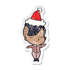 distressed sticker cartoon of a squinting girl wearing santa hat