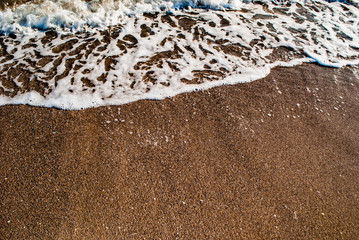 sand and sea foam on the beach
