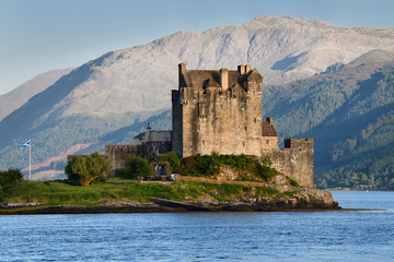 Evening sunlight on Eilean Donan Castle on Island where three Lochs meet and Beinn a' Chuirn mountain in Glenelg Scottish Highlands Scotland