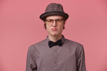 Closeup portrait skeptical young man looking disrespectful, dissatisfied, pessimistic, full of...