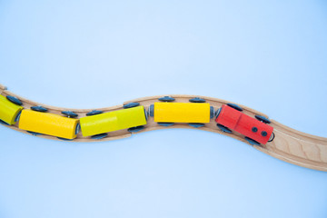 Top view on multicolor kids toy train cars bricks on wooden railway blue background. Copyspase. flat lay. Children toys on the table