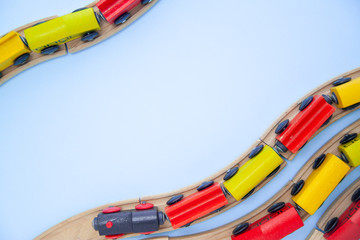 frame for text made of multicolor kids train cars bricks on wooden railway on blue background. Copyspase. top view. flat lay. Children toys on the table.