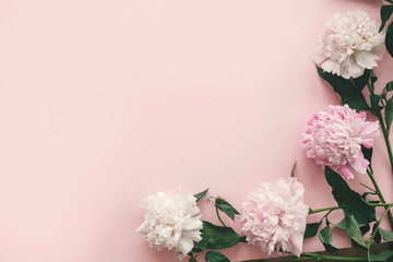Stylish pink and white peonies border on pink paper flat lay with space for text. Happy mother's day. International womens day. Greeting card mockup. Creative Hello spring image © sonyachny