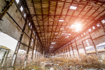 Interior of old factory building destroyed with holes in roof and walls. Ruins of industrial enterprise, pieces of debris crumbling in factory as result of economic crisis and earthquake