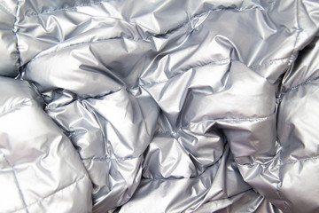 textile and texture concept - close up of crumpled gray silver metallic fabric background.