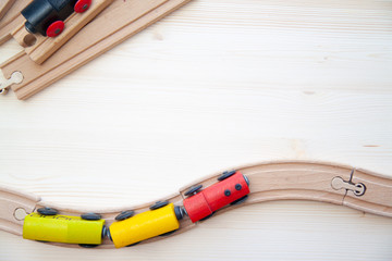 Top view on multicolor kids toy train cars bricks on wooden railway blue background. Copyspase....