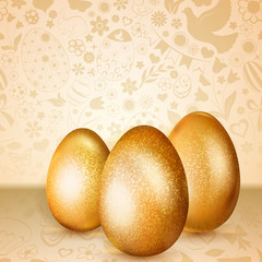 Three golden Easter eggs standing on background of flowers, cakes, hare, chicken and other holiday symbols