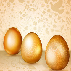 Three golden Easter eggs standing on background of flowers, cakes, hare, chicken and other holiday symbols