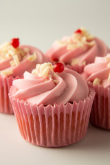 Close up pink, strawbery, fruit cupcakes isoalted. Sweet dessert, shortcakes with cream. Birthday food, cake, muffin. Tempalte for sugar addicted post for social media food content. Vertical image.