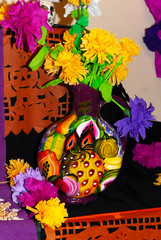 Día de Muertos: Ofrenda, traditional altar with offerings to the ancestors, paper flowers in a vase painted with tropical fruits