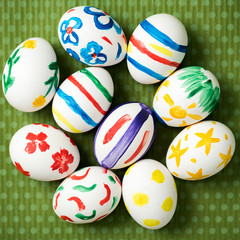 Easter eggs painted by hand on a beautiful green background in white peas. Festive background. Easter ideas. Space for text. Happy easter.