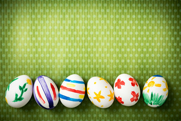 Easter eggs painted by hand on a beautiful green background in white peas. Festive background. Easter ideas. Space for text. Happy easter.