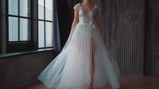 charming angel, new story about Cinderella and Snow White. attractive blond lady in long luxurious dress with open back and train posing for the camera and fun throws train and hem of dress up