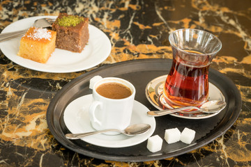 Obraz na płótnie Canvas traditional Turkish red black tea tulip glass green flowers sweet dessert afternoon tea break