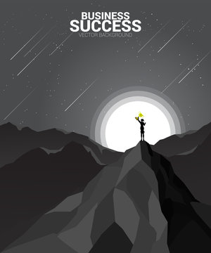 Silhouette of businesswoman with thophy on top of mountain. business concept of leadership and championship.