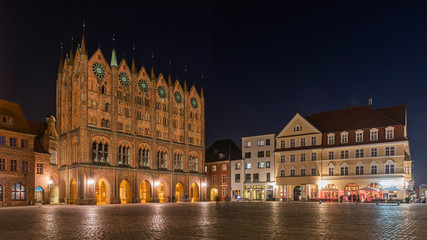 Fototapeta na wymiar Stralsund – Rathaus mit Schaufassade, dahinter die Nikolaikirche am Alten Markt bei Nacht